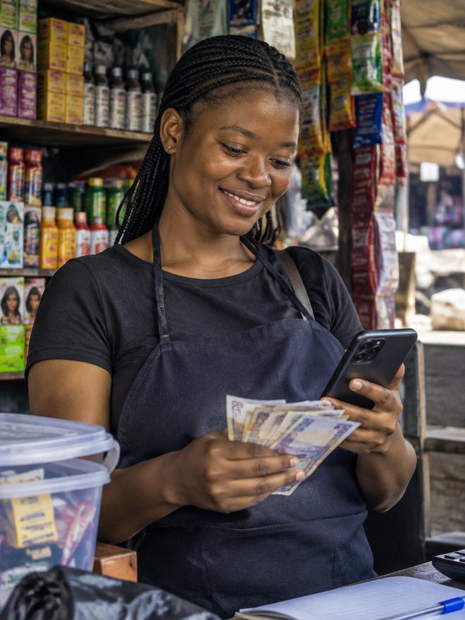 A young reseller in her shop counting cash